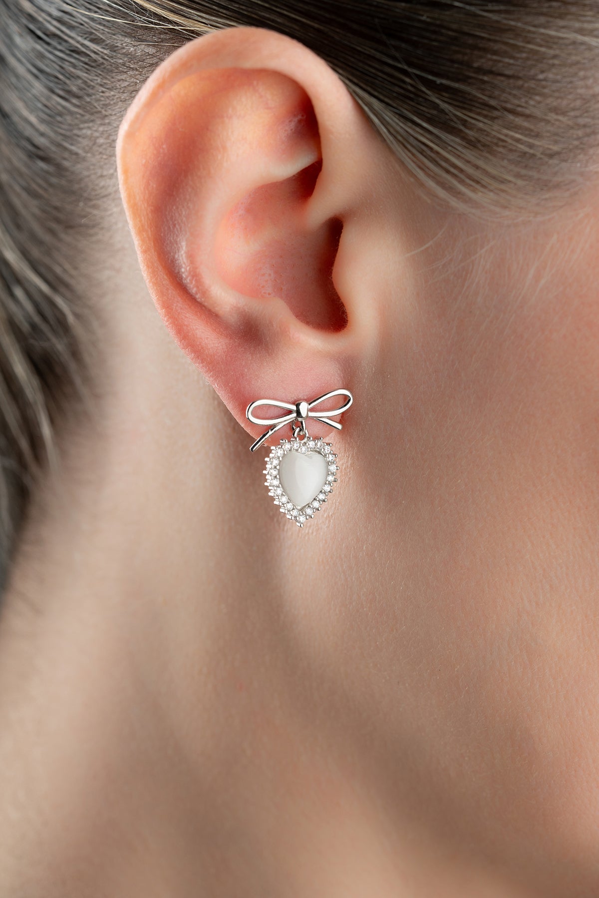 Boucles d'oreilles en argent avec des détails de cœur et d'arc