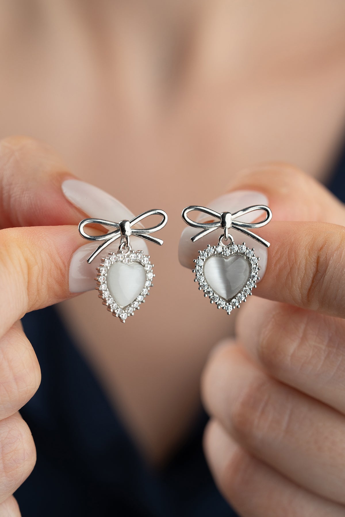 Boucles d'oreilles en argent avec des détails de cœur et d'arc