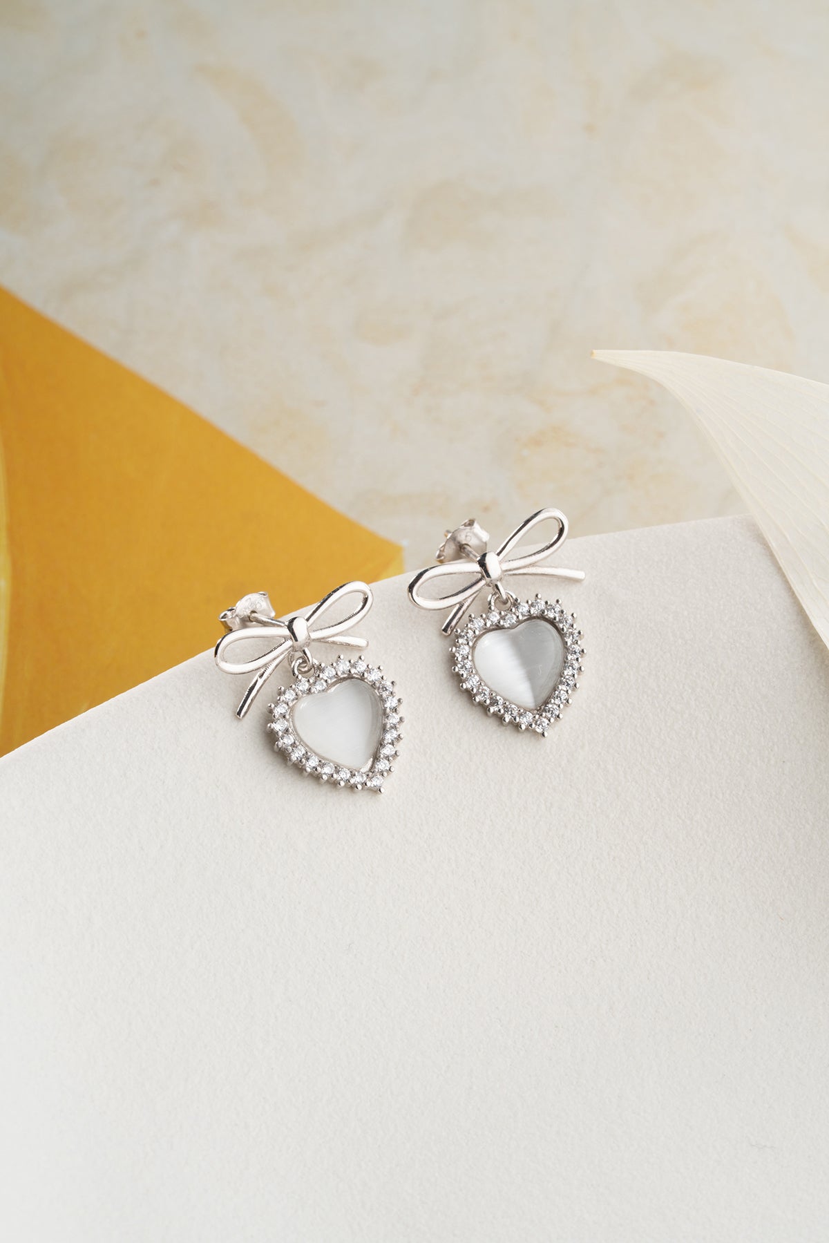 Boucles d'oreilles en argent avec des détails de cœur et d'arc