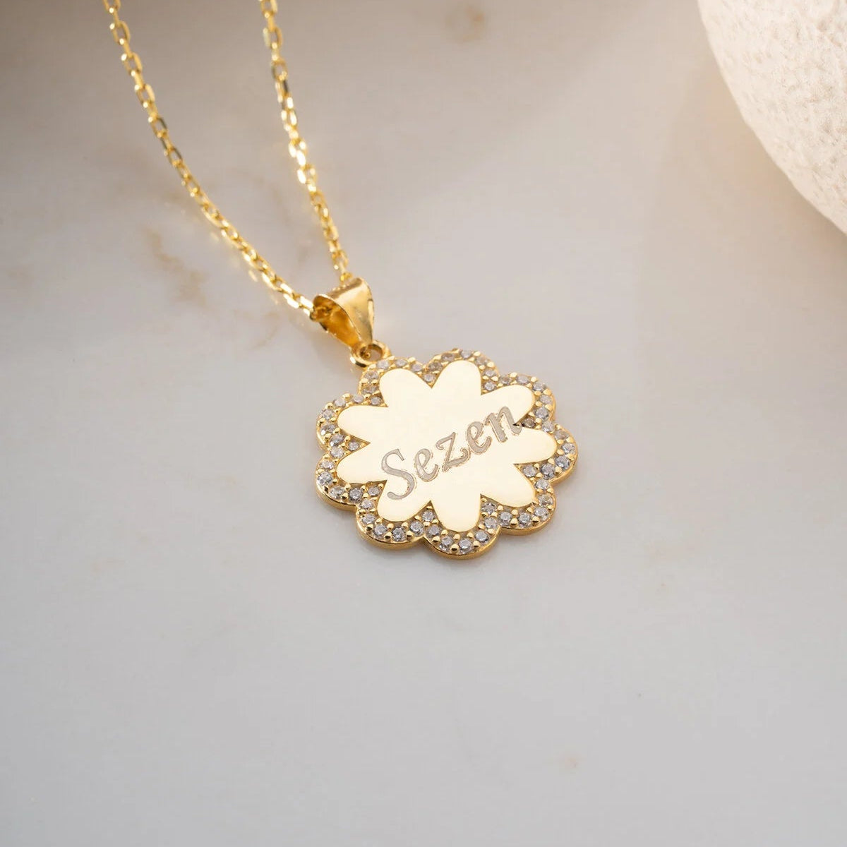 Detailfoto van bloemvormige naamketting met schitterende zirkonia’s