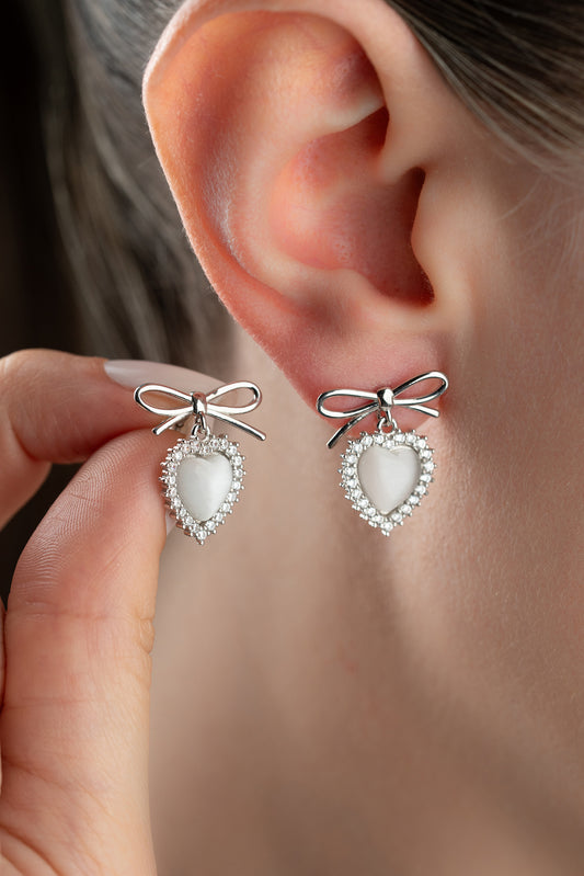 Boucles d'oreilles en argent avec des détails de cœur et d'arc