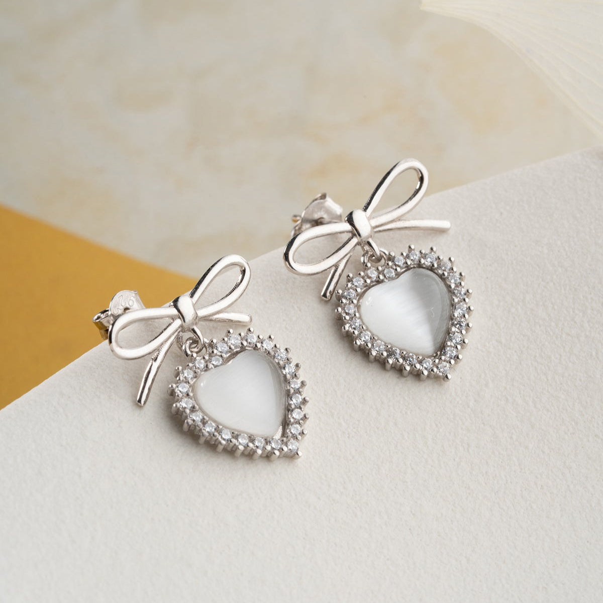 Boucles d'oreilles en argent avec des détails de cœur et d'arc
