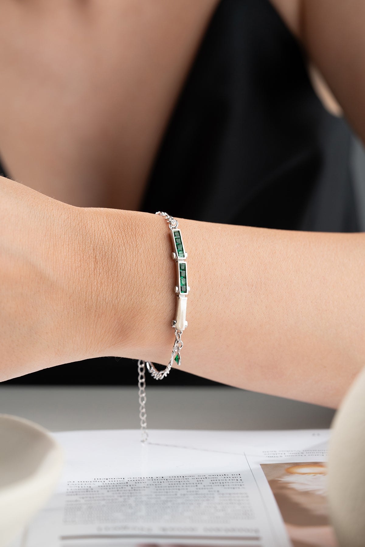Bracelet en argent avec des pierres vertes et une conception de chaîne fine