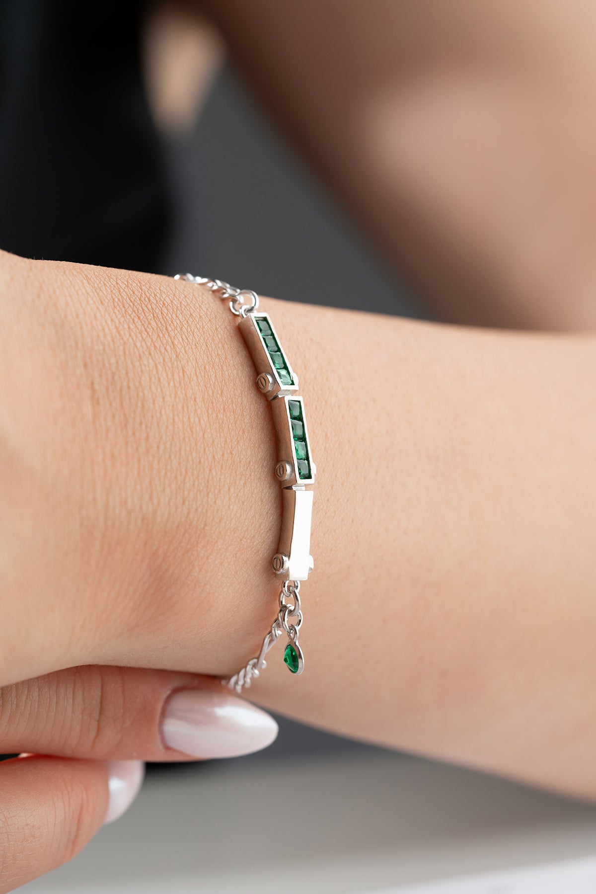 Bracelet en argent avec des pierres vertes et une conception de chaîne fine