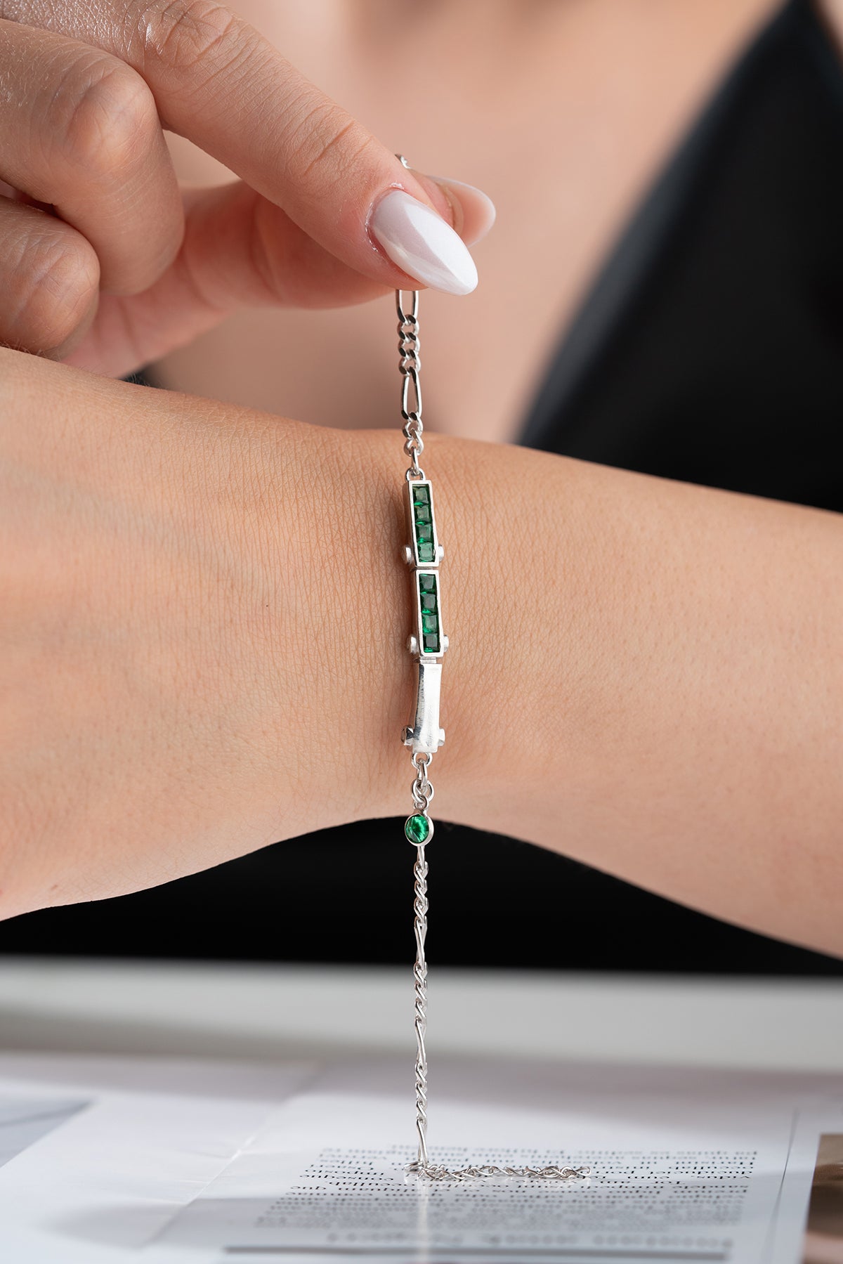 Bracelet en argent avec des pierres vertes et une conception de chaîne fine